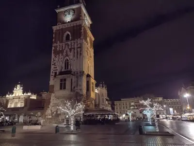 a large clock tower in a city at night at Cracowapart Ignacio A in Kraków