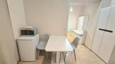 a white table and chairs in a room with a microwave at Topolowa Apartament z klimatem- Topolowa/Rynek/PKP in Kraków