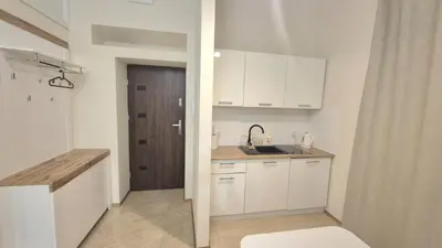 a kitchen with white cabinets and a wooden door at Topolowa Apartament z klimatem- Topolowa/Rynek/PKP in Kraków