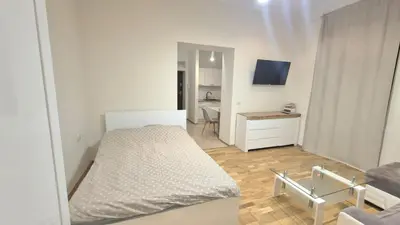 a small white bedroom with a bed and a desk at Topolowa Apartament z klimatem- Topolowa/Rynek/PKP in Kraków