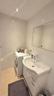 a bathroom with a sink and a washing machine at Topolowa Apartament z klimatem- Topolowa/Rynek/PKP in Kraków