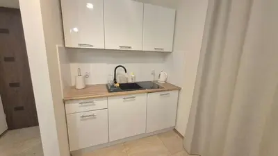 a kitchen with white cabinets and a sink at Topolowa Apartament z klimatem- Topolowa/Rynek/PKP in Kraków