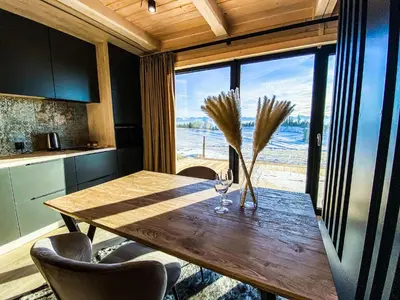 a house with large windows and a black roof at Osada Janosika Jacuzzi Drewniany Domek Na Odludziu in Klikuszowa