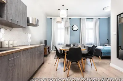 a kitchen and dining room with a table and chairs at City of the Kings - Mosaic Apartment in Kraków