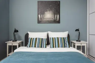 a bedroom with a bed with two night stands at City of the Kings - Mosaic Apartment in Kraków