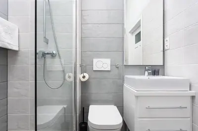 a bathroom with a shower and a toilet and a sink at City of the Kings - Mosaic Apartment in Kraków