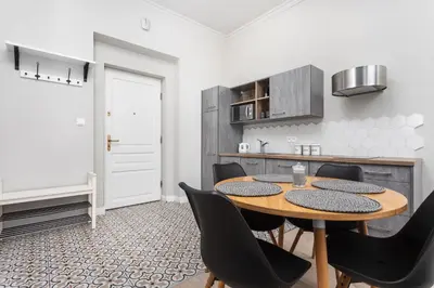a kitchen and dining room with a table and chairs at City of the Kings - Mosaic Apartment in Kraków