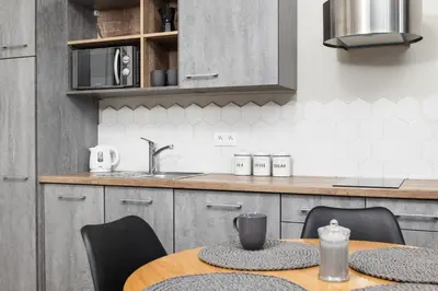 a kitchen with a table with chairs and a sink at City of the Kings - Mosaic Apartment in Kraków
