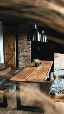 a wooden table in a room with a brick wall at Beskidzki Reset in Budzów