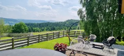 a patio with a table and chairs and a fence at Beskidzki Reset in Budzów