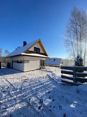 a white house with a fence in the snow at Beskidzki Reset in Budzów