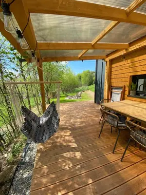a wooden deck with a table and chairs on it at Czill-Lokum- klimatyczna chata w Beskidach z balią i sauną in Maków Podhalański