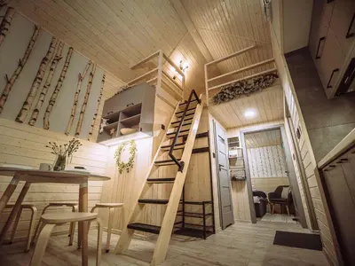 a tiny house with a staircase and a table and chairs at Czill-Lokum- klimatyczna chata w Beskidach z balią i sauną in Maków Podhalański