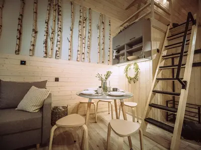 a tiny room with a table and chairs and a staircase at Czill-Lokum- klimatyczna chata w Beskidach z balią i sauną in Maków Podhalański
