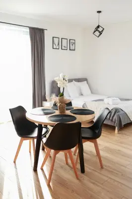 a living room with a table and chairs and a bed at RABA RESORT - Domki i Apartamenty pod Krakowem in Gdów