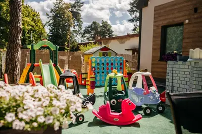 a childrens playground with toys on the grass at RABA RESORT - Domki i Apartamenty pod Krakowem in Gdów