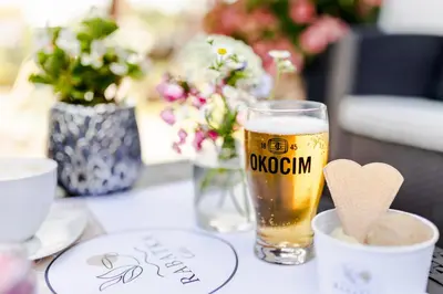 a glass of beer sitting on top of a table at RABA RESORT - Domki i Apartamenty pod Krakowem in Gdów