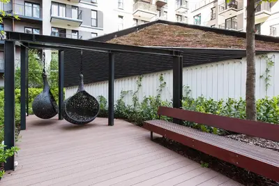 a wooden deck with two swings and a bench at Central Apartments by Bed&Bath in Kraków