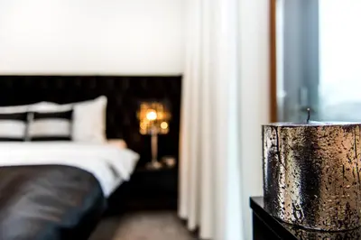 a bedroom with a bed and a wooden stump in the foreground at Central Apartments by Bed&Bath in Kraków