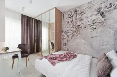 a bedroom with a bed and a desk and a wall at Central Apartments by Bed&Bath in Kraków