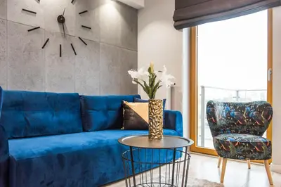 a blue couch and a chair in a living room at Central Apartments by Bed&Bath in Kraków