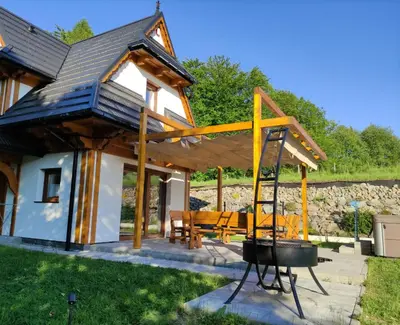 a house with a grill in front of it at Zacna Chata domek z jacuzzi na wyłączność in Półrzeczki