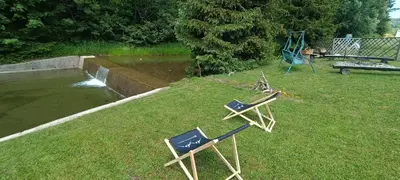 two lawn chairs on the grass next to a playground at Apartamenty Obidowa in Obidowa