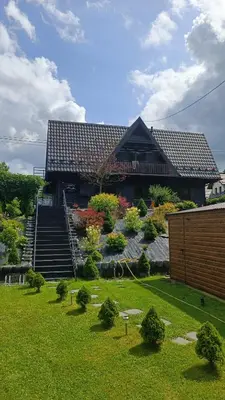 a large building with stairs in front of a yard at Apartamenty Obidowa in Obidowa