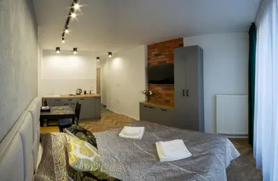 a bedroom with a bed with two towels on it at Apartamenty U Pana Cogito in Kraków