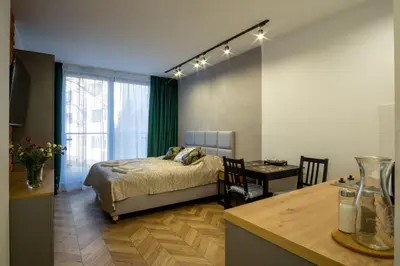 a bedroom with a bed and a desk and a table at Apartamenty U Pana Cogito in Kraków