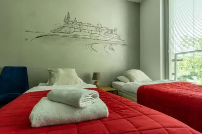 a bedroom with two beds and a drawing on the wall at Apartamenty U Pana Cogito in Kraków