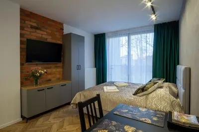 a bedroom with a bed and a television and a table at Apartamenty U Pana Cogito in Kraków