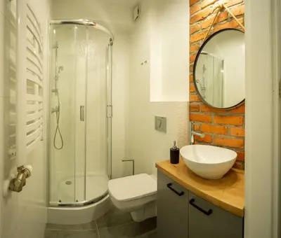 a bathroom with a toilet and a sink and a shower at Apartamenty U Pana Cogito in Kraków
