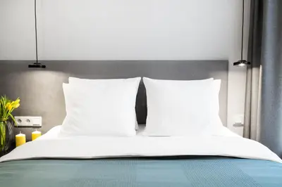 a bed with white sheets and pillows on it at HOUSEHOST Apartment: Miodowa 42/30 Street in Kraków
