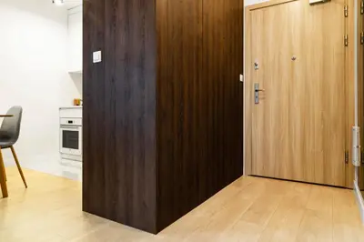 a wooden door in a room with a kitchen at HOUSEHOST Apartment: Miodowa 42/30 Street in Kraków