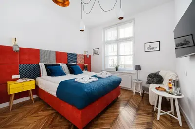 a bedroom with a large bed with a red headboard at Luxury SPA Apartment Old Town Krakow in Kraków