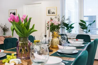 a dining room table with plates and vases of flowers at Luxury SPA Apartment Old Town Krakow in Kraków