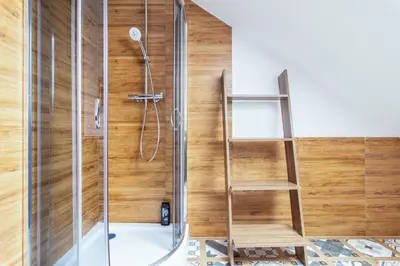 a shower with a glass door and a wooden wall at THE CASTLE - Free Parking - Self Check In in Kraków