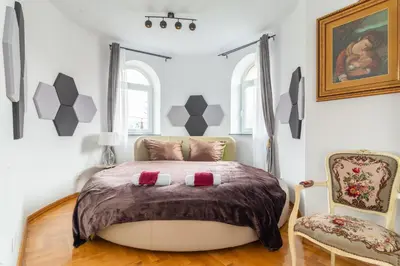 a bedroom with a large bed and two chairs at THE CASTLE - Free Parking - Self Check In in Kraków
