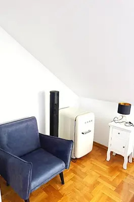 a living room with a blue chair and a heater at THE CASTLE - Free Parking - Self Check In in Kraków