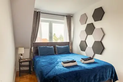 a bedroom with a blue bed with two bags on it at THE CASTLE - Free Parking - Self Check In in Kraków