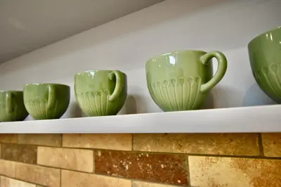 a shelf with green cups on top of a fireplace at Kraków Krib in Kraków