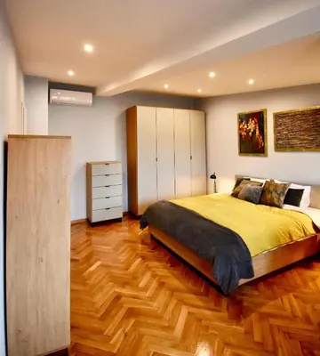 a bedroom with a large bed and a wooden floor at Kraków Krib in Kraków