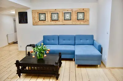 a blue couch in a living room with a table at Kraków Krib in Kraków