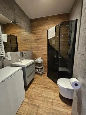 a bathroom with a shower and a toilet and a sink at Steam Park Rakowicka Koper Apartment in Kraków
