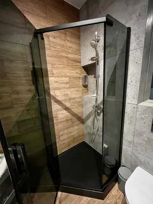 a shower with a glass door in a bathroom at Steam Park Rakowicka Koper Apartment in Kraków