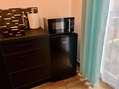 a microwave sitting on top of a black refrigerator at Steam Park Rakowicka Koper Apartment in Kraków