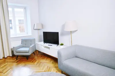 a living room with a couch and a chair and a television at 21 Floriańska Street Apartments in Kraków