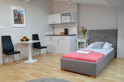 a bedroom with a bed and a small kitchen at 21 Floriańska Street Apartments in Kraków
