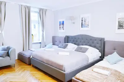 a bedroom with two beds and a chair at 21 Floriańska Street Apartments in Kraków